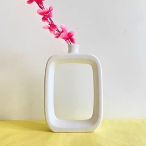Minimalist white hollow geometric ceramic vase on tabletop