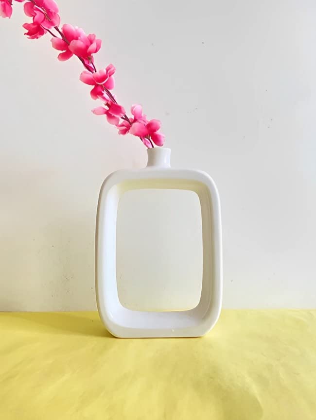 Minimalist white hollow geometric ceramic vase on tabletop