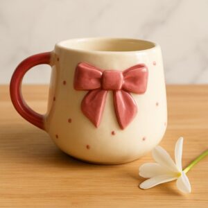 Aesthetic ceramic mug with 3D pink bow and polka dots styled with white flower